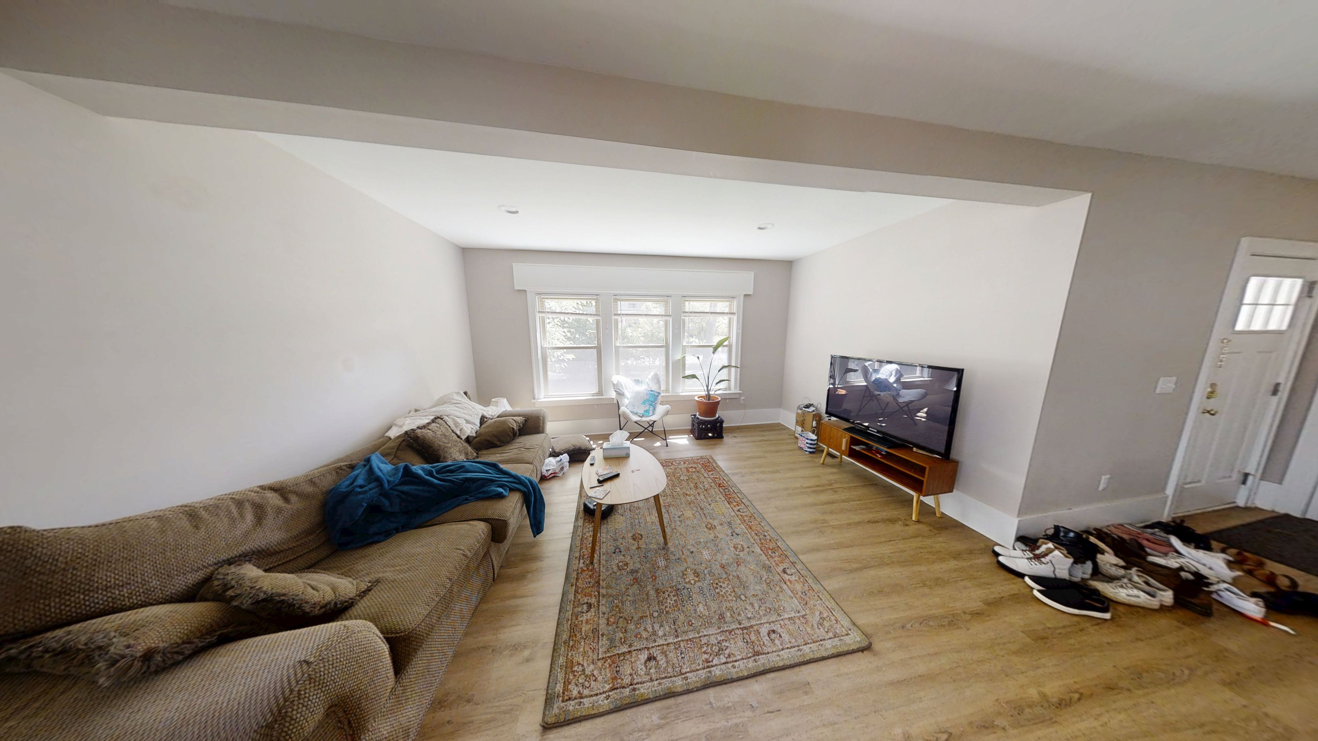 A living room with a couch, rug, and television.